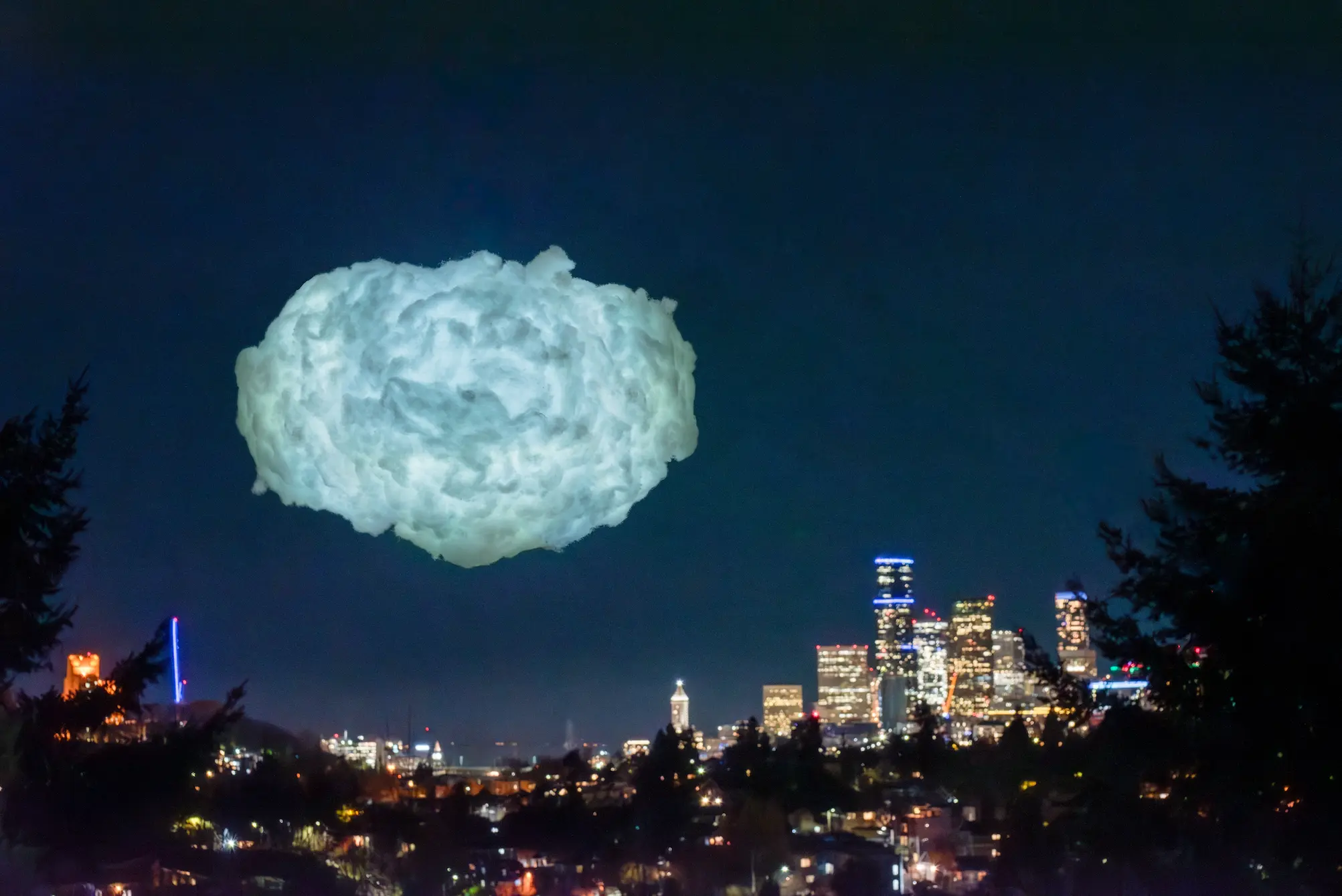 A glowing cloud floats above the Seattle skyline.