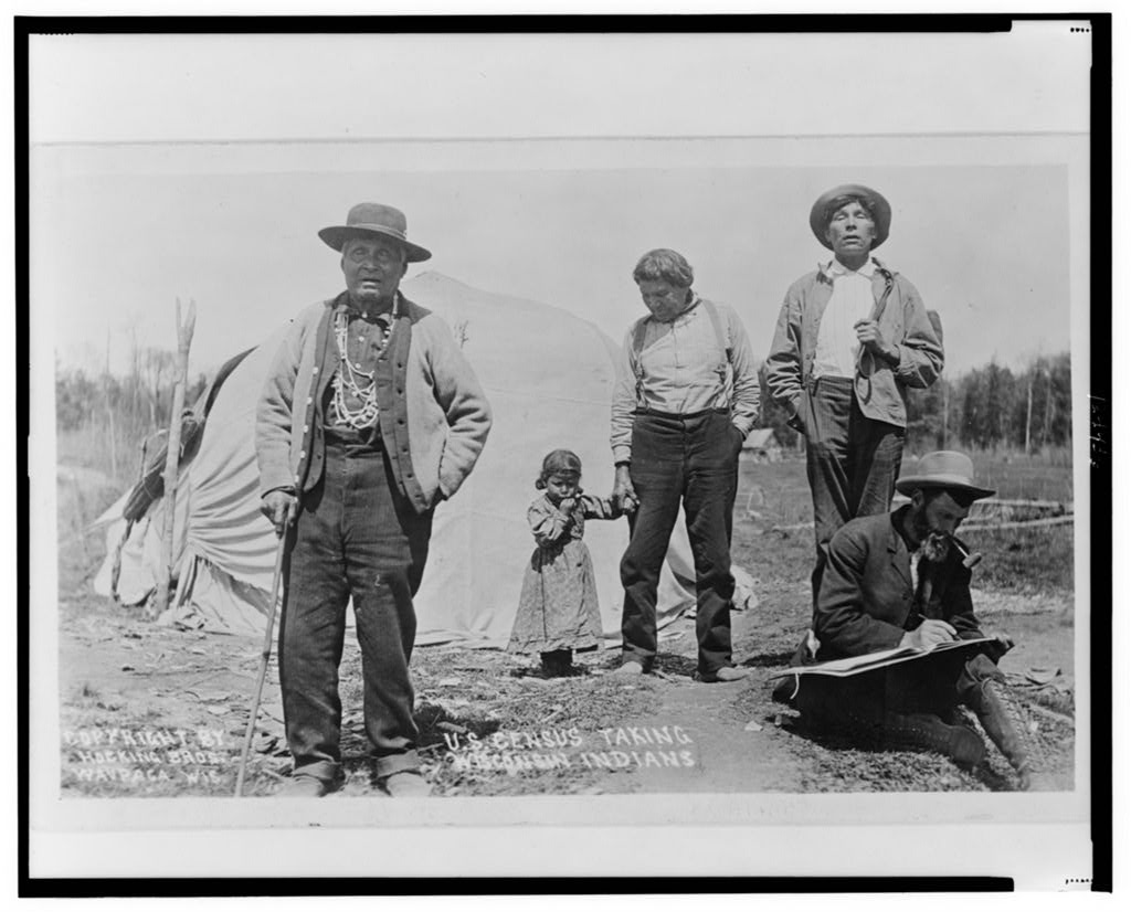 Photograph of a man taking the census from a group of Winnebago people in Wisconsin